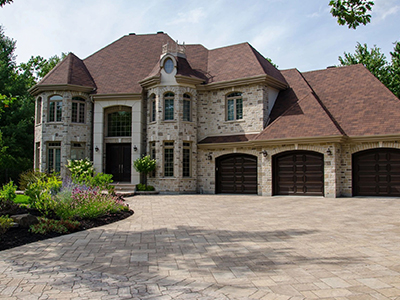 A large brick house with two garages and a driveway.